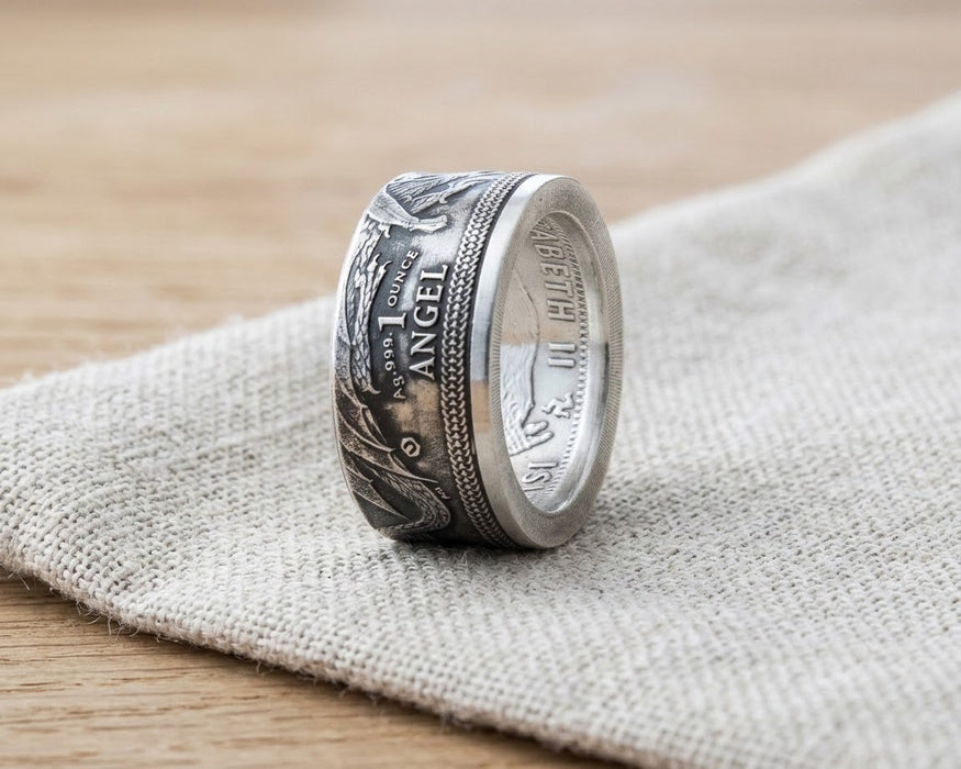 Isle of Man silver Angel coin ring resting on linen - Minted Jewellery