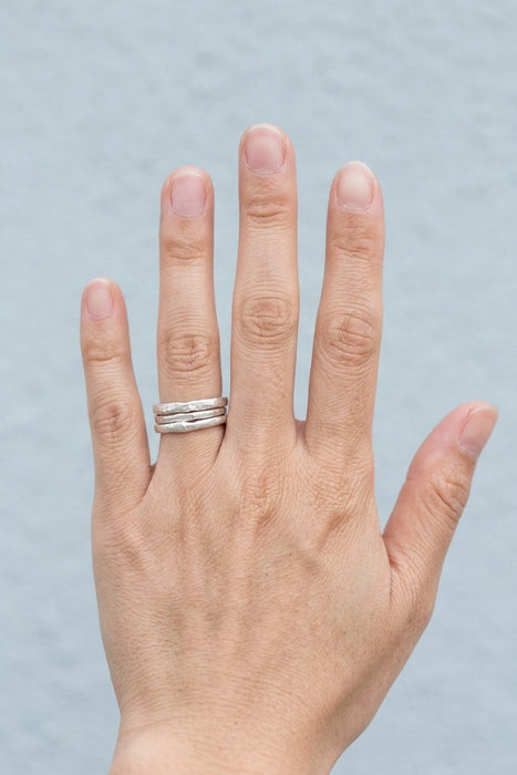 Three hammered silver stacking rings worn together on the ring finger - Minted Jewellery